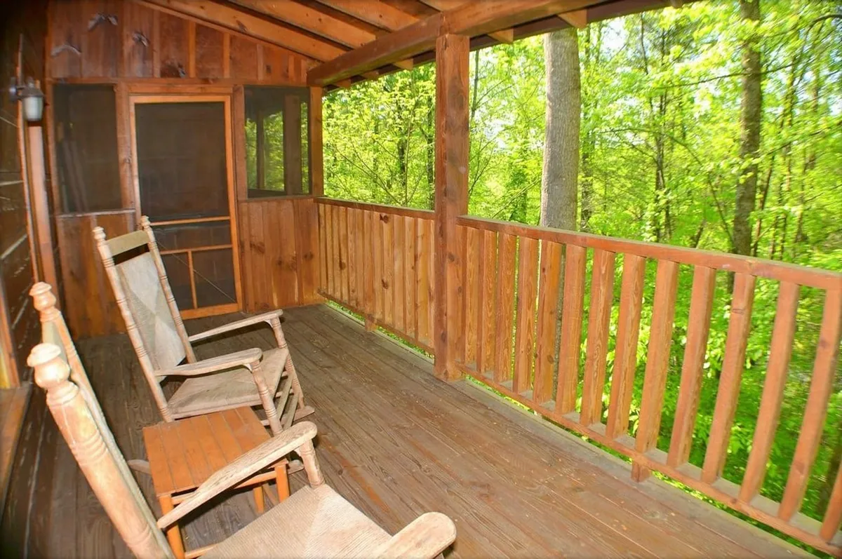This image features a charming wooden deck outfitted with classic rocking chairs, overlooking lush greenery. The serene setting is perfect for relaxing, birdwatching, or simply soaking in the peaceful mountain environment. Sunlight dapples the deck, suggesting an inviting spot to start or end your day surrounded by nature.